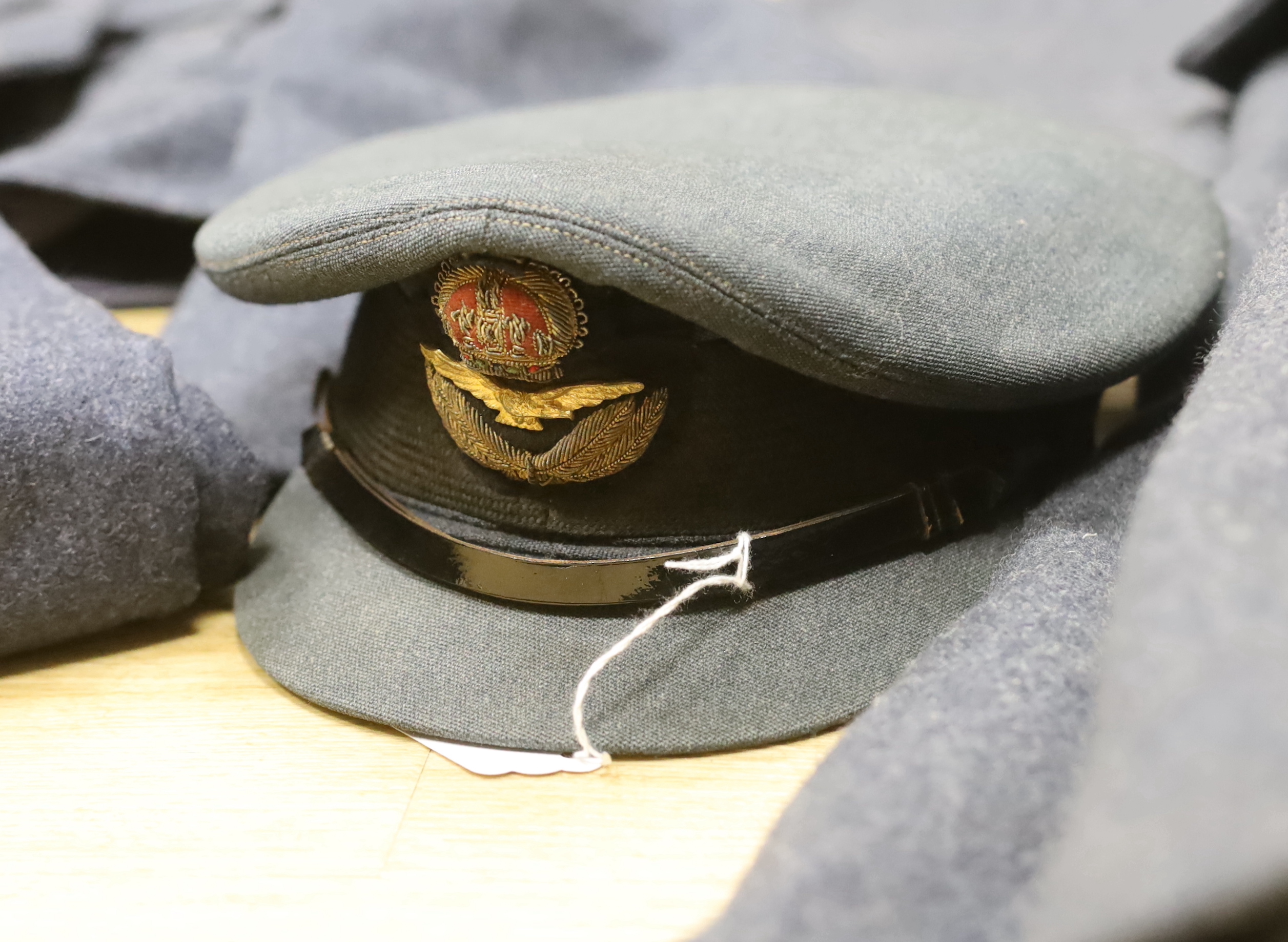 A 1960s RAF uniform comprising; great coat, blouse, cap and trousers, all with manufacturer’s labels, broad arrow markings, dates, etc.